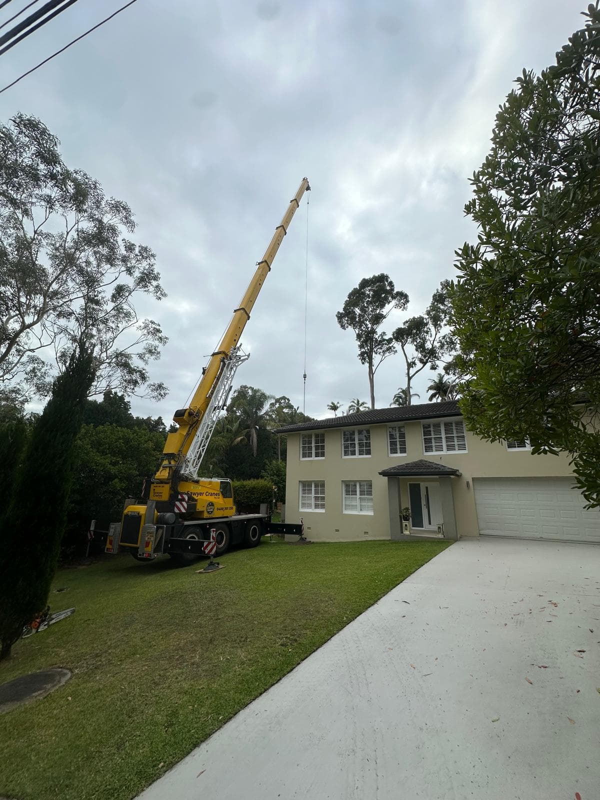 Sawyer Cranes mobile crane set up on the front lawn of a St Ives home before a large eucalypt removal